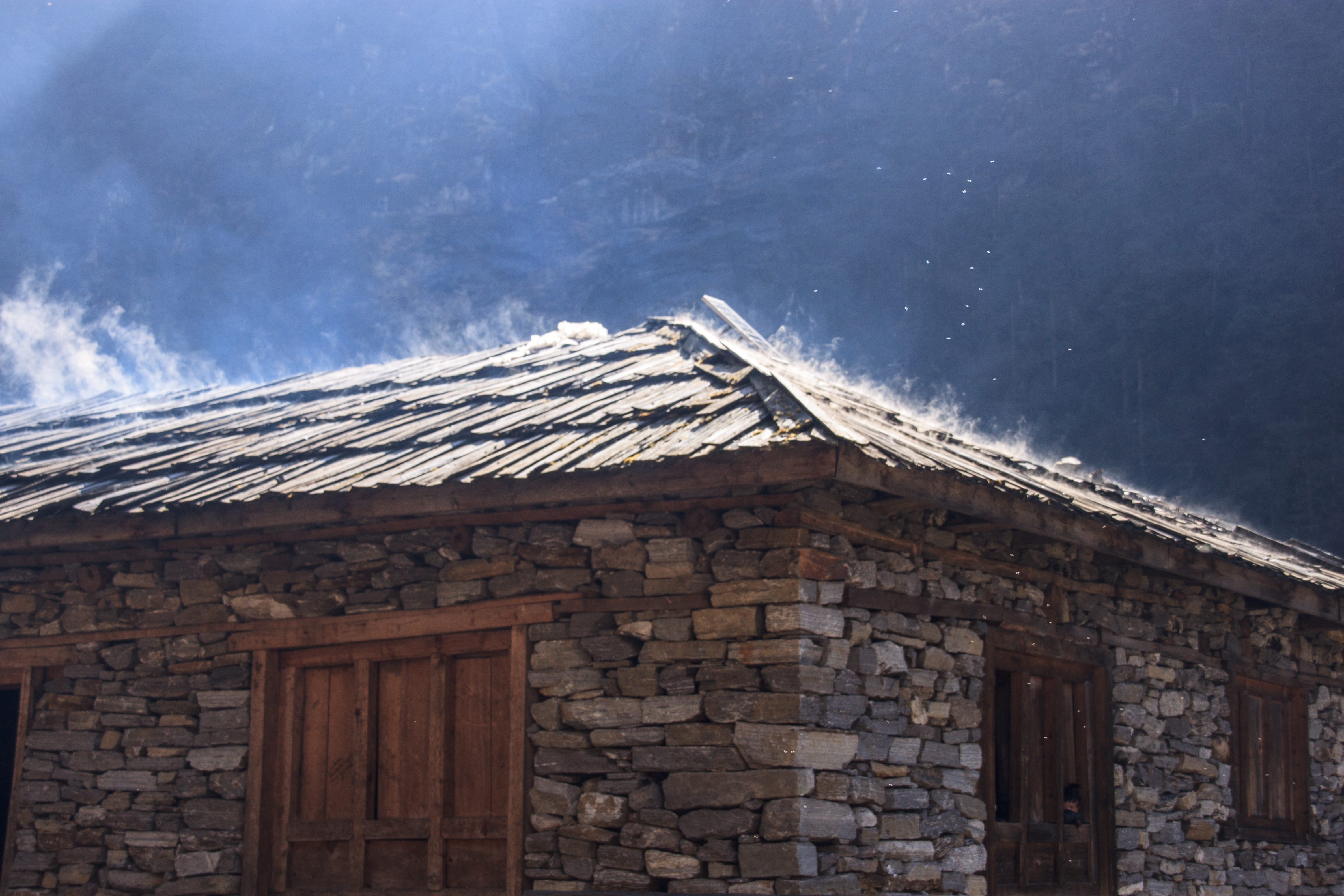 Smoke rising through the roof of a house in Khote.