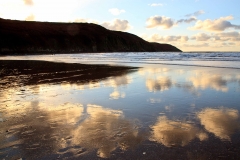 Baggy Point and evening clouds reflected on Putsborough Beach